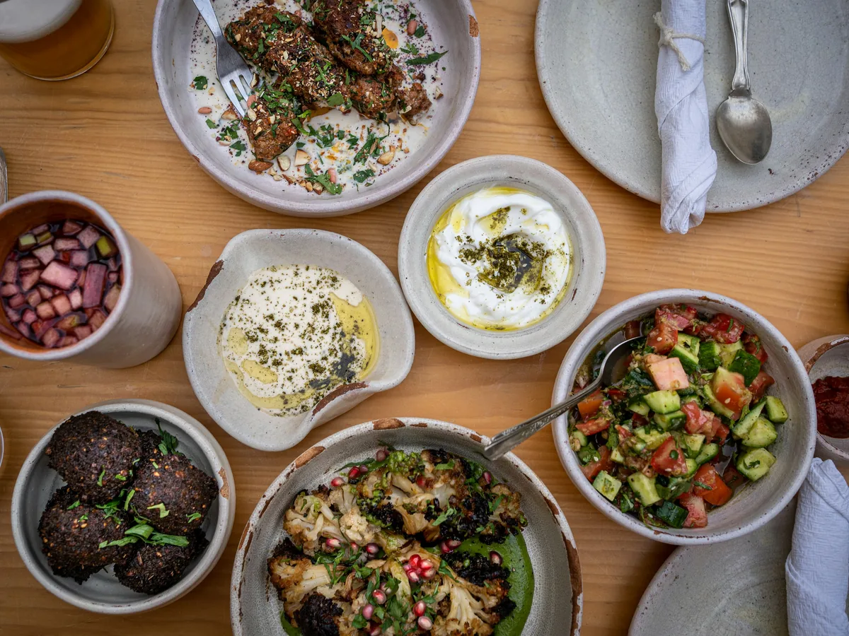 A wooden table set with bowls of food for sharing